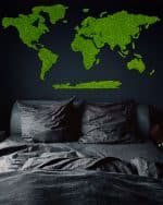 Mapa świata z chrobotka zawieszona w ciemnym pokoju nad łóżkiem