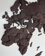 Mapa świata 3D w kolorze czekolady Drewniana mapa świata 3D w kolorze czekolady zawieszona na białej ścianie.